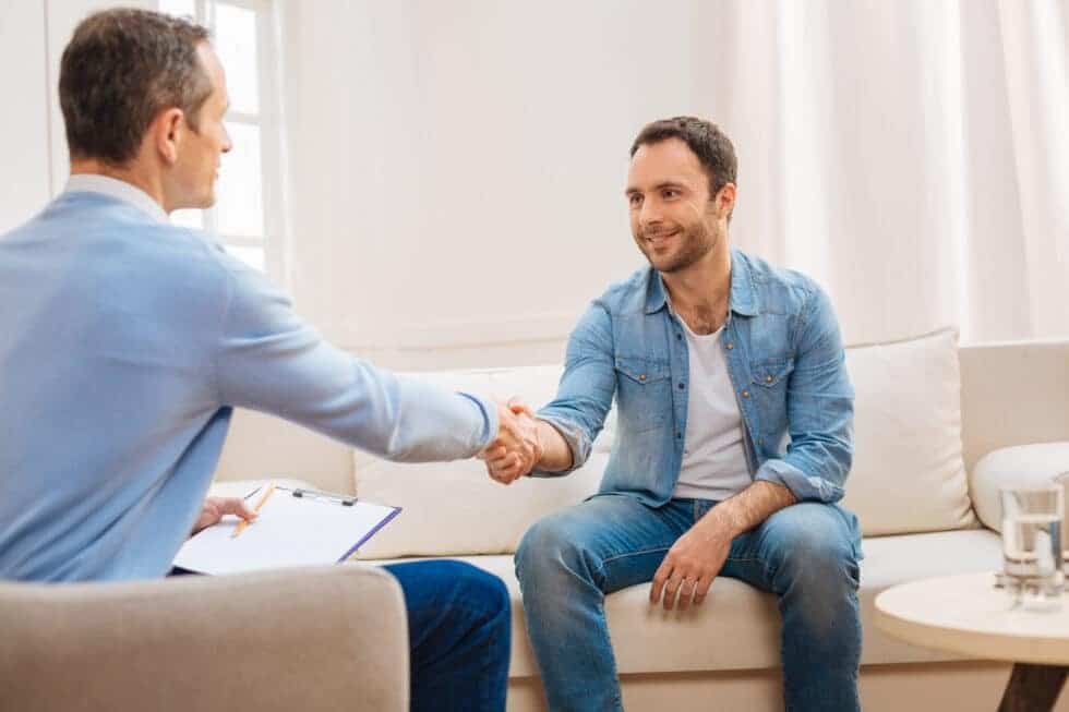 Man in sobriety shaking employers hand